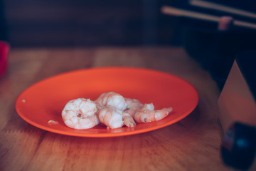Boiled Shrimp. A pile of orange boiled shrimp peeled with tails still attached ready to eat