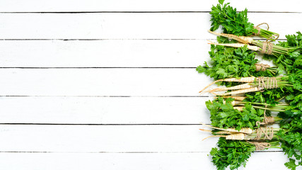 Parsley root on a white wooden background. Top view. Free space for your text.