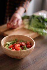 Man cutting green lettuce for salad
