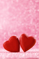 Two red hearts on bokeh background