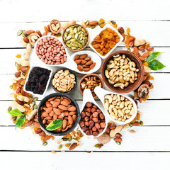 Assorted nuts on a white wooden background. Top view. Free space for your text.