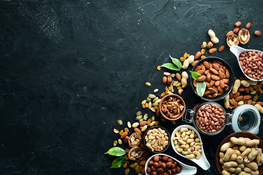 Assorted nuts on the old black background. Top view. Free space for your text.