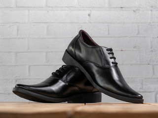 Men fashion black shoes on wood.