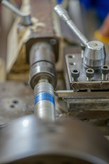 The lathe machine cutting the thread on the steel shaft.The turning machine making the thread on the steel shaft