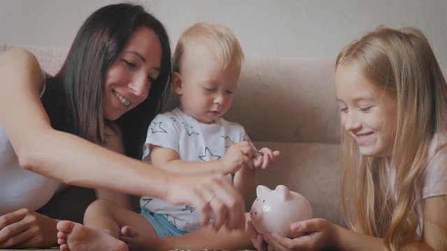 Mother and two children saving money to piggy bank. Family earning money for future. Investment concept.