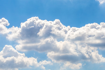 The white fluffy clouds and light blue sky in the sunny day. 