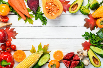 Fresh autumn vegetables and fruits on white wooden background. Healthy food. Top view. Free copy space.