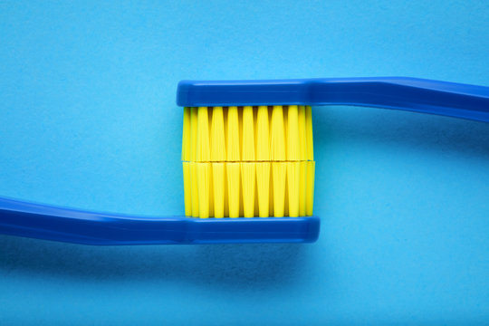 Toothbrushes displaying the stained teeth on blue background