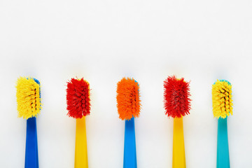 Colorful used worn old toothbrushes in a row on white background
