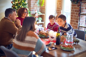 Beautiful family smiling happy and confident. Eating roasted turkey celebrating christmas at home