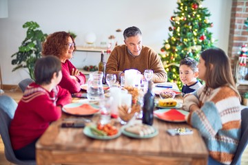 Beautiful family smiling happy and confident. Eating roasted turkey celebrating christmas at home