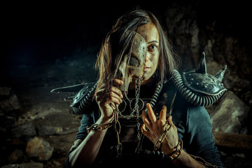 Post-apocalyptic woman in the rusty skull mask on the dungeon background. Nuclear post-apocalypse...