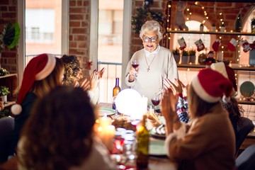 Beautiful group of women smiling happy and confident. On of them holding cup of wine speaking speech celebrating christmas at home