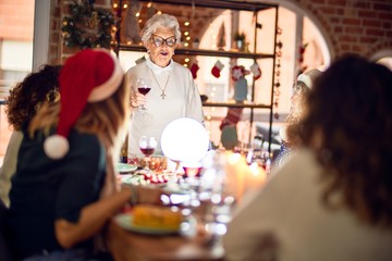 Beautiful group of women smiling happy and confident. On of them holding cup of wine speaking speech celebrating christmas at home