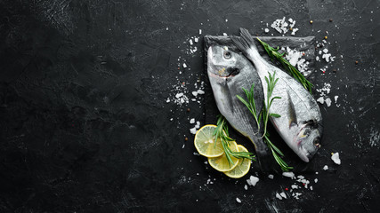 Raw dorado fish with lemon and spices on a black background. Top view. Free space for your text. - Powered by Adobe