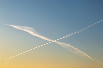 Fototapeta na wymiar Vapour trails forming a cross in the sky at sunset