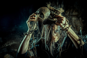 Post-apocalyptic woman in the rusty skull mask on the dungeon background. Nuclear post-apocalypse time. Life after doomsday