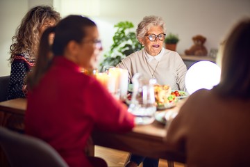 Beautiful group of women smiling happy and confident. Eating roasted turkey celebrating thanksgiving day at home