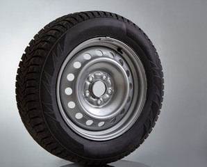Fototapeta premium Car wheel and winter studded tire on white