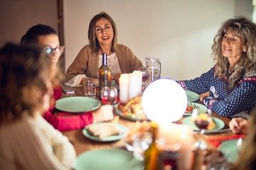 Beautiful group of women smiling happy and confident. Eating roasted turkey celebrating thanksgiving day at home