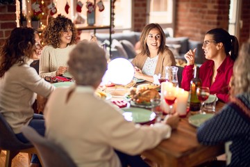 Beautiful group of women smiling happy and confident. Eating roasted turkey celebrating christmas at home