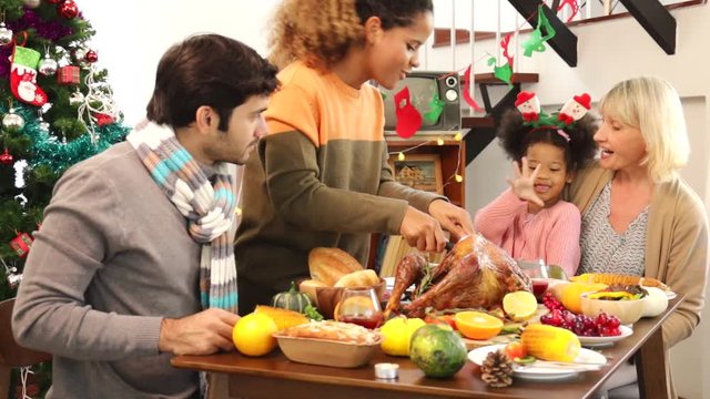 Thanksgiving Celebration Tradition Family Dinner Concept.family having holiday dinner and cutting turkey.Young black adult woman and her daughter happy.