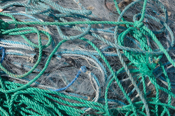 A tangled mess of fishing nets plastic rope and other debris washed up on a coastal beach ideal for...
