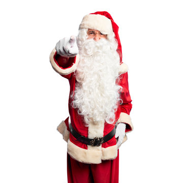 Middle age handsome man wearing Santa Claus costume and beard standing pointing displeased and frustrated to the camera, angry and furious with you