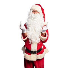 Middle age handsome man wearing Santa Claus costume and beard standing Showing middle finger doing...