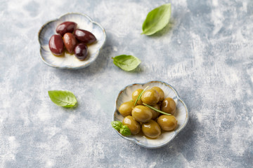 Green and kalamata olives on bright wooden background. Copy space. 