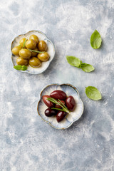 Green and kalamata olives on bright wooden background. Top view. Copy space. 