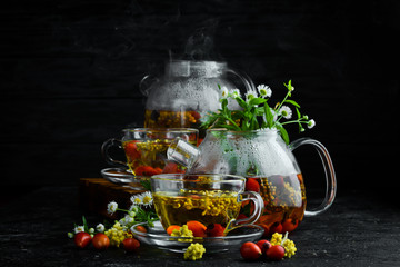 Chamomile and wild rose tea. Hot winter drinks. On a black background. Top view.