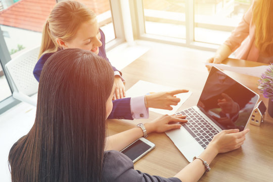 Business internship supervisor. Caucasian businesswoman pointing at laptop screen for young intern.