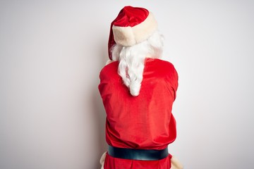 Fototapeta na wymiar Middle age handsome man wearing Santa costume standing over isolated white background standing backwards looking away with crossed arms