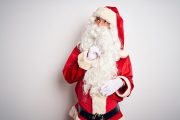 Middle age handsome man wearing Santa costume standing over isolated white background Thinking concentrated about doubt with finger on chin and looking up wondering