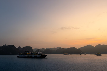 Naklejka premium Ha Long Bay in Vietnam during a beautiful Sunset with calm, tranquil seas. Shot in Autumn 2019 from a cruise ship tour