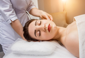Fototapeta na wymiar Beautiful young woman enjoying head massage in spa salon. Cosmetology