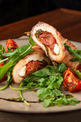 close-up meatloaf with baked tomatoes and green arugula on beige plate at restaurant