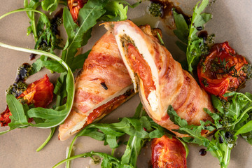 close-up meatloaf with baked tomatoes and green arugula on beige plate at restaurant, top view