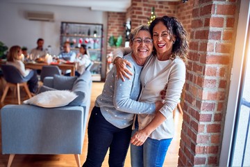 Family and friends dining at home celebrating christmas eve with traditional food and decoration, women talking together happy and casual
