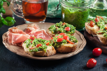 Bruschetta with fresh pesto, mozzarella and cherry tomatoes on a plate