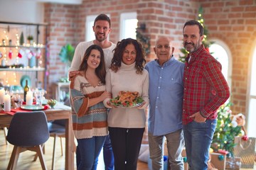 Beautiful family smiling happy and confident. Standing and posing with tree celebrating Christmas at home