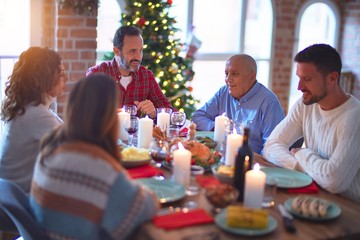 Beautiful family smiling happy and confident. Eating roasted turkey celebrating Christmas at home