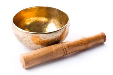 Closeup of a singing bowl and its mallet on a white backround