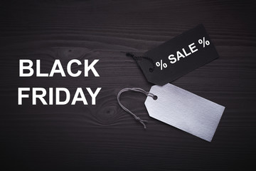 Black Friday text on a black tag on black paper background