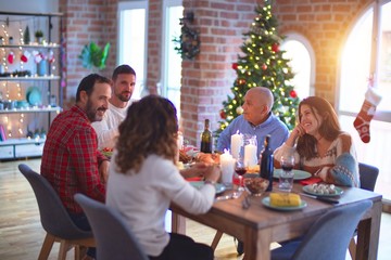 Beautiful family smiling happy and confident. Eating roasted turkey celebrating Christmas at home