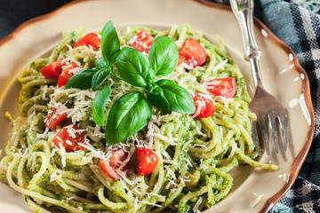 Vegetarian pasta spaghetti with basil pesto and cherry tomatoes