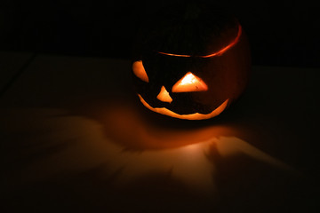 Alone head of the pumpkin inside the dark room. Only candle make a light during october halloween...