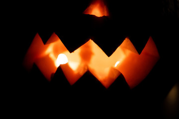 Alone head of the pumpkin inside the dark room. Only candle make a light during october halloween...