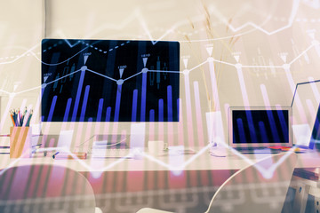 Stock market graph on background with desk and personal computer. Multi exposure. Concept of financial analysis.